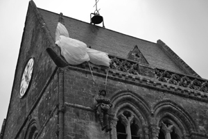 Paracaidista en la iglesia de Saint Mère Église en recuerdo de Jhon Steele