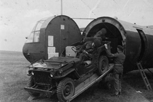 tropas paracaidistas de la 1ª división cargan un vehículo en un planeador