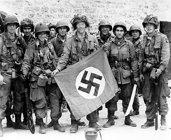 Miembros de la 101ª división aerotransportada mostrando una bandera capturada