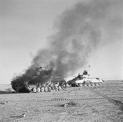 Un carro crusader avanza por detrás de un panzer IV destruido. Imagen de dominio público cortesía del Imperial War Museum, E6751